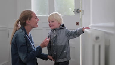 Mother and child kissing goodbye at home