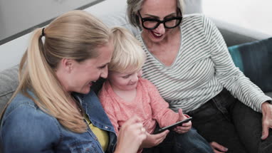 Three generations of family using a smartphone