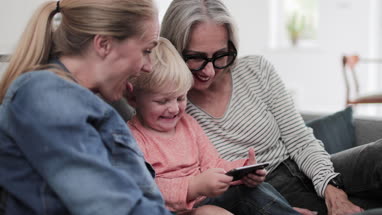 Three generations of family using a smartphone