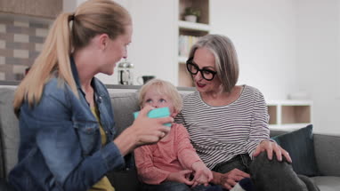 Mature adult female being given a gift by her family