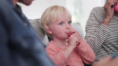 Boy trying to blow up birthday balloons with family