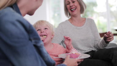 Boy eating birthday cake at a family celebration