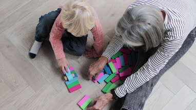 Overhead shot of grandson playing with grandmother at home