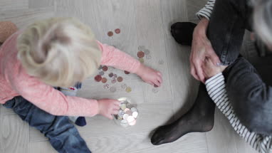 Overhead shot of grandmother helping grandchild count pocket money