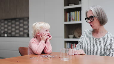 Grandmother helping grandchild count pocket money