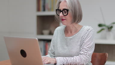 Mature adult female paying bill online using a laptop