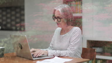 Mature adult female paying bill online using a laptop