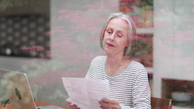 Mature adult female paying bill online using a laptop