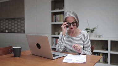 Mature adult female paying bill online using a laptop