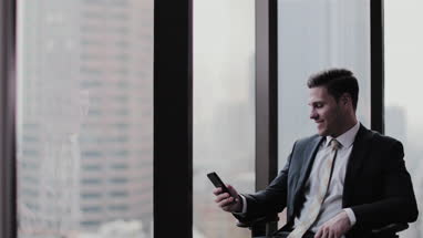 Businessman using smartphone in office skyscraper