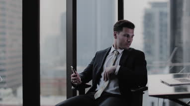 Businessman using smartphone in office skyscraper