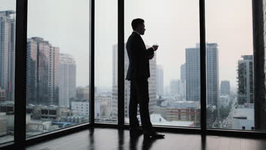 Businessman using smartphone in skyscraper office