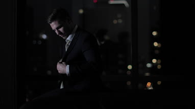 Businessman finishing work lat at night and checking smartphone 