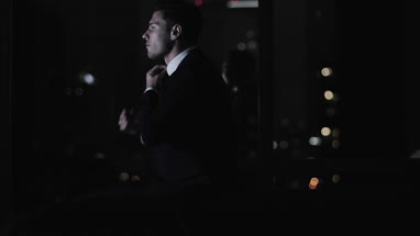 Businessman finishing work lat at night and checking smartphone 