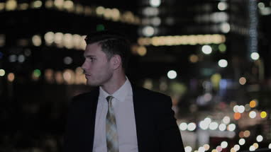 Portrait of businessman in city at night