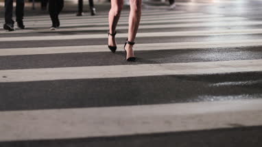 Closeup of woman in high heels walking across a crosswalk 