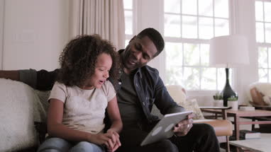African American father and daughter using digital tablet together