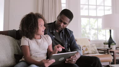 African American father and daughter using digital tablet together