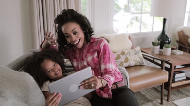 African American mother and daughter using digital tablet for a videocall