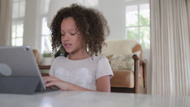 African American girl using digital tablet for homework