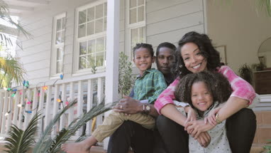Portrait of African American family sitting outside home