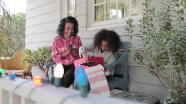 African American mother giving daughter a christmas gift