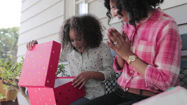 African American mother giving daughter a christmas gift