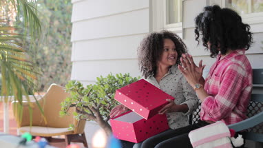 African American mother giving daughter a christmas gift