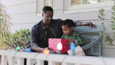 African American father giving son a christmas gift