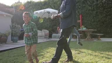 African American family playing football in yard