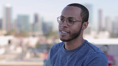 Portrait of African American young adult male outdoors in summer