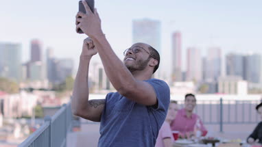 Group of friends taking selfie with city skyline in background