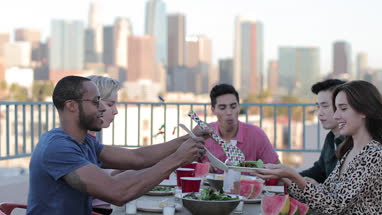 Group of friends gathering on a rooftop for a meal