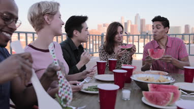Group of friends gathering on a rooftop for a meal