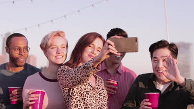 Group of friends taking selfie with city skyline in background