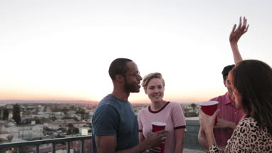 Group of friends dancing at a rooftop party