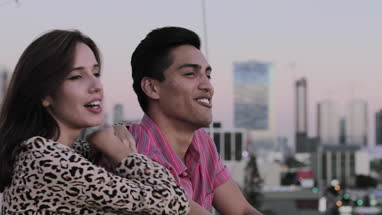 Young adult couple looking out across city skyline