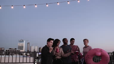 Group of friends dancing at a rooftop party