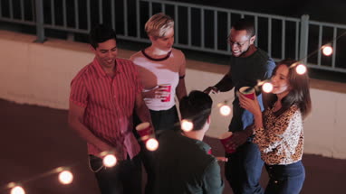 Overhead shot of group of friends dancing at a rooftop party