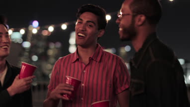 Group of male friends at a rooftop party