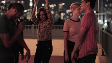 Group of friends dancing at a rooftop party