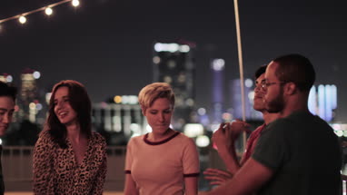 Group of friends dancing at a rooftop party