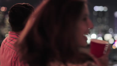 Young adult couple looking at city skyline at a party