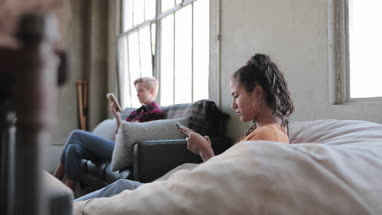 Young adult friends socialising whilst on their smartphones