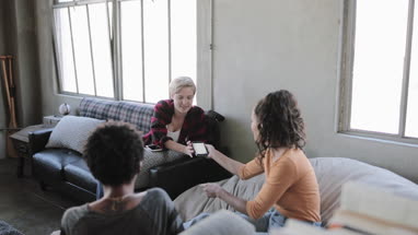 Young adult friends looking at a smartphone together 