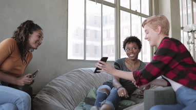 Young adult friends looking at a smartphone together 