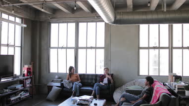 Young adult friends socialising whilst on their smartphones