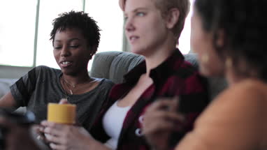 Young adult friends socialising in a loft apartment
