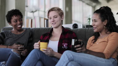 Young adult friends socialising in a loft apartment