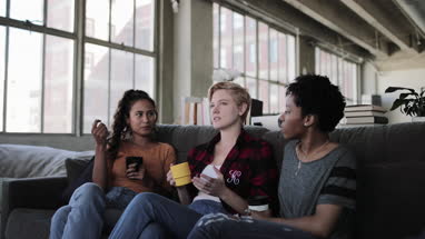 Young adult friends socialising in a loft apartment